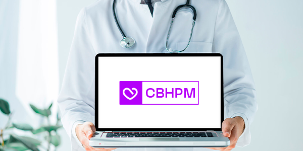 Médico segurando um notebook com a sigla CBHPM na tela